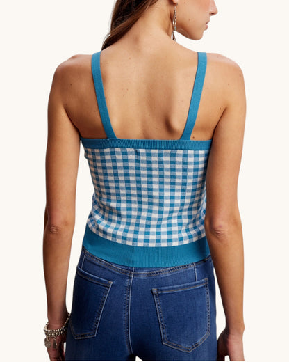Woman wearing a blue and white checkered top with open back.
