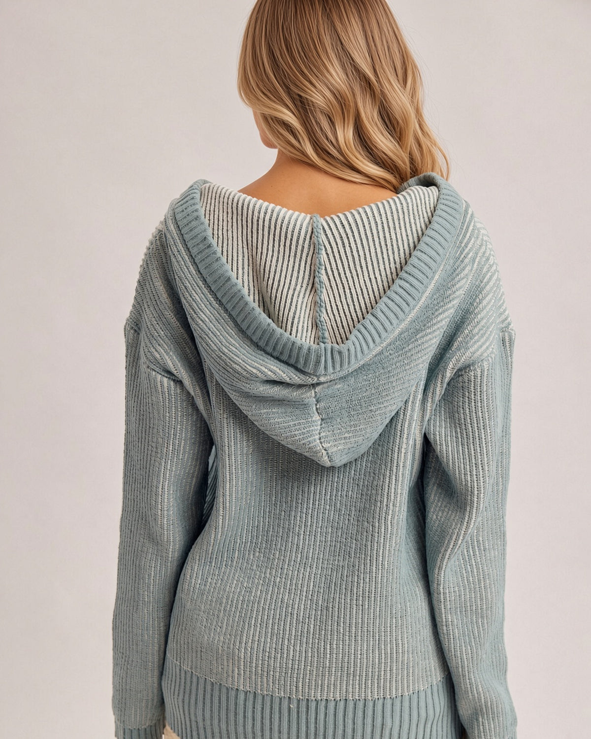 Back view of the Chill Factor dusty teal sweater hoodie, showing the hood, two-tone knit, and ribbed hem. 