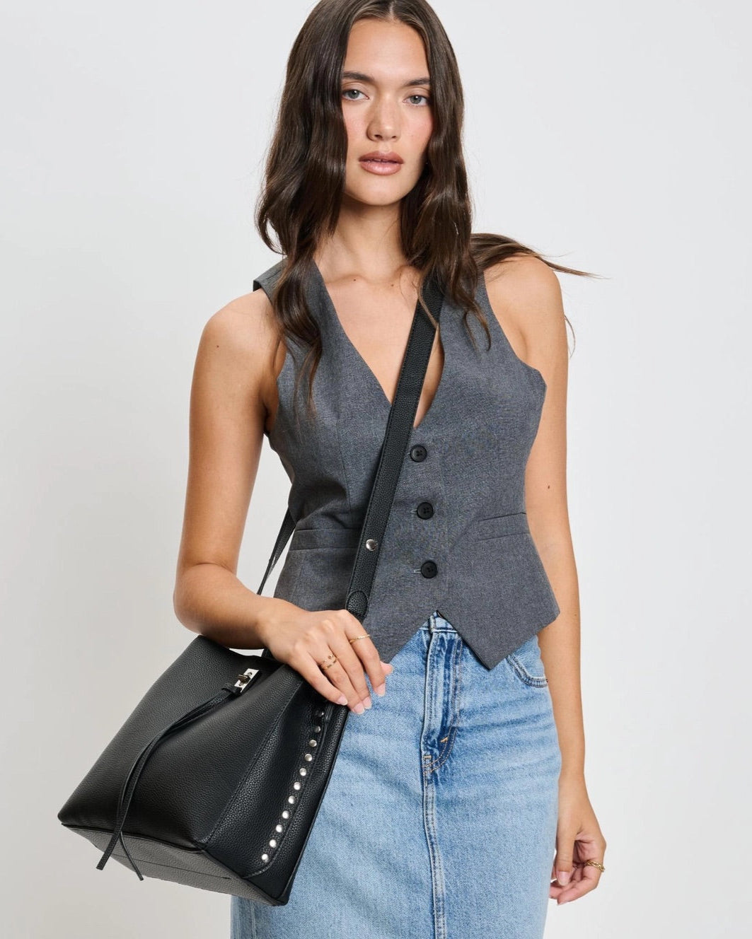 Eliza tassel vegan leather crossbody handbag with studs and turn lock in Almond or Black.