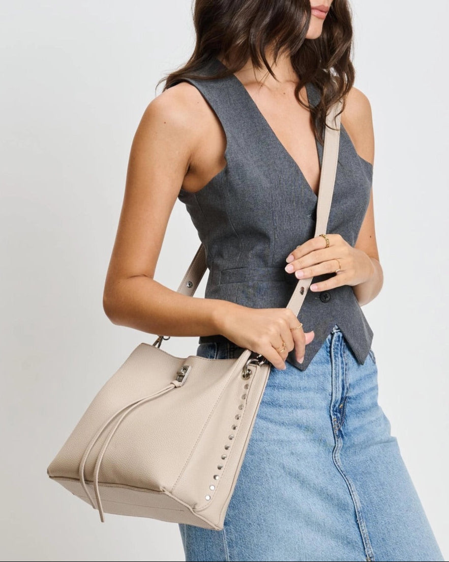 Eliza tassel vegan leather crossbody handbag with studs and turn lock in Almond or Black.