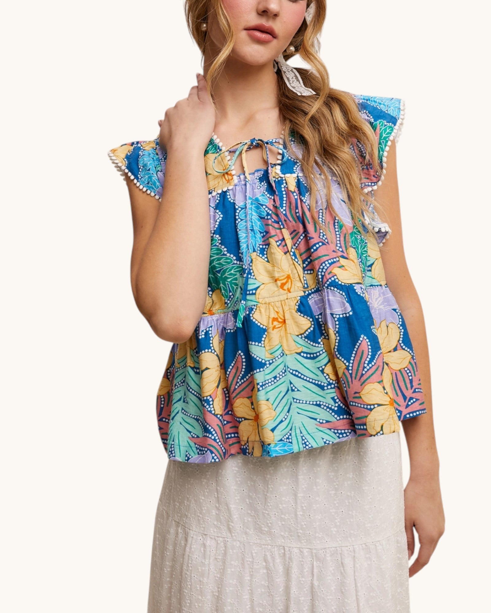 Woman wearing the Waikiki Bloom Tropical Tie Front Top with white skirt.