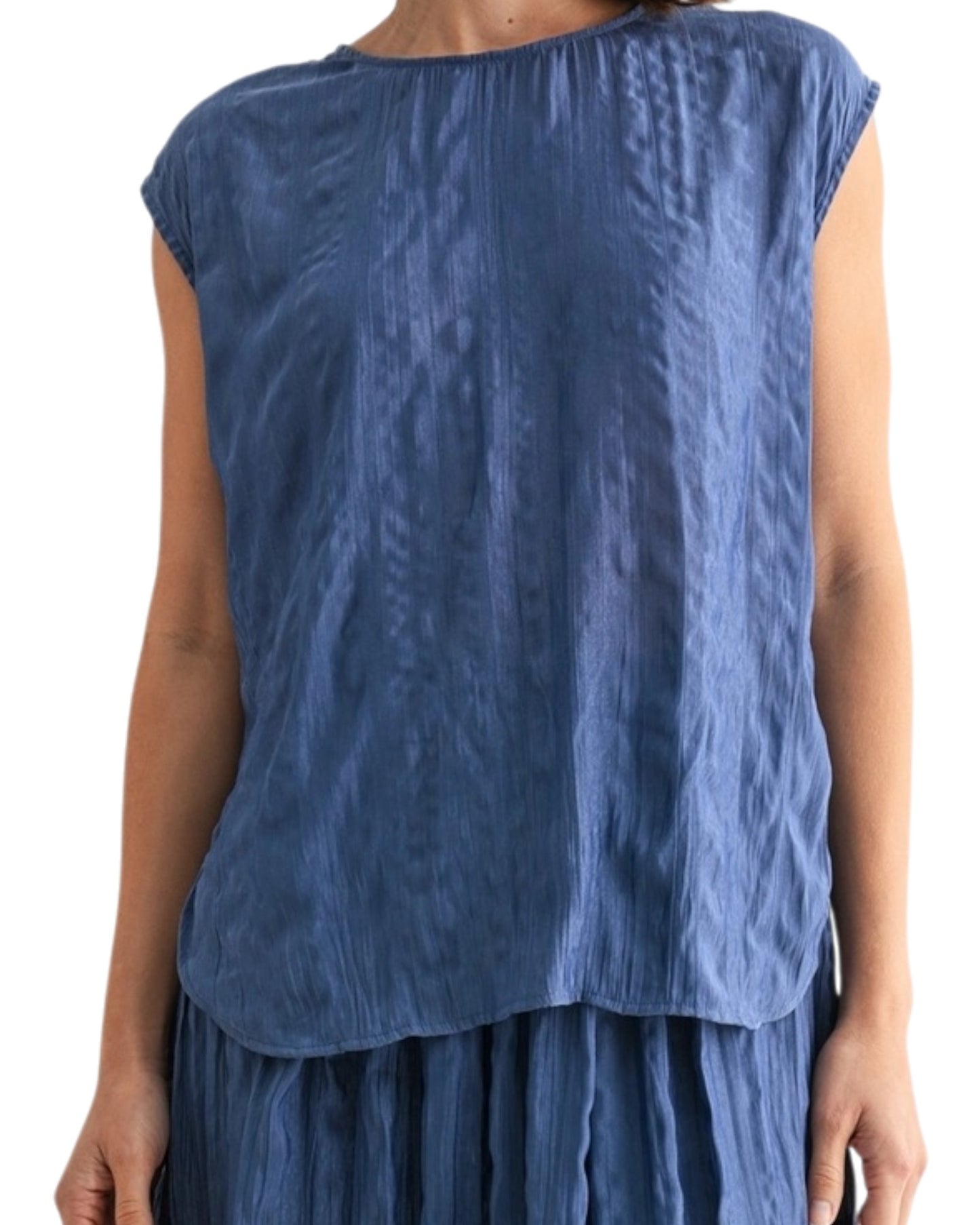 Woman wearing a blue textured sleeveless top on a white background.