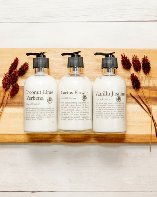 Goat milk lotion in glass bottles on wood background.