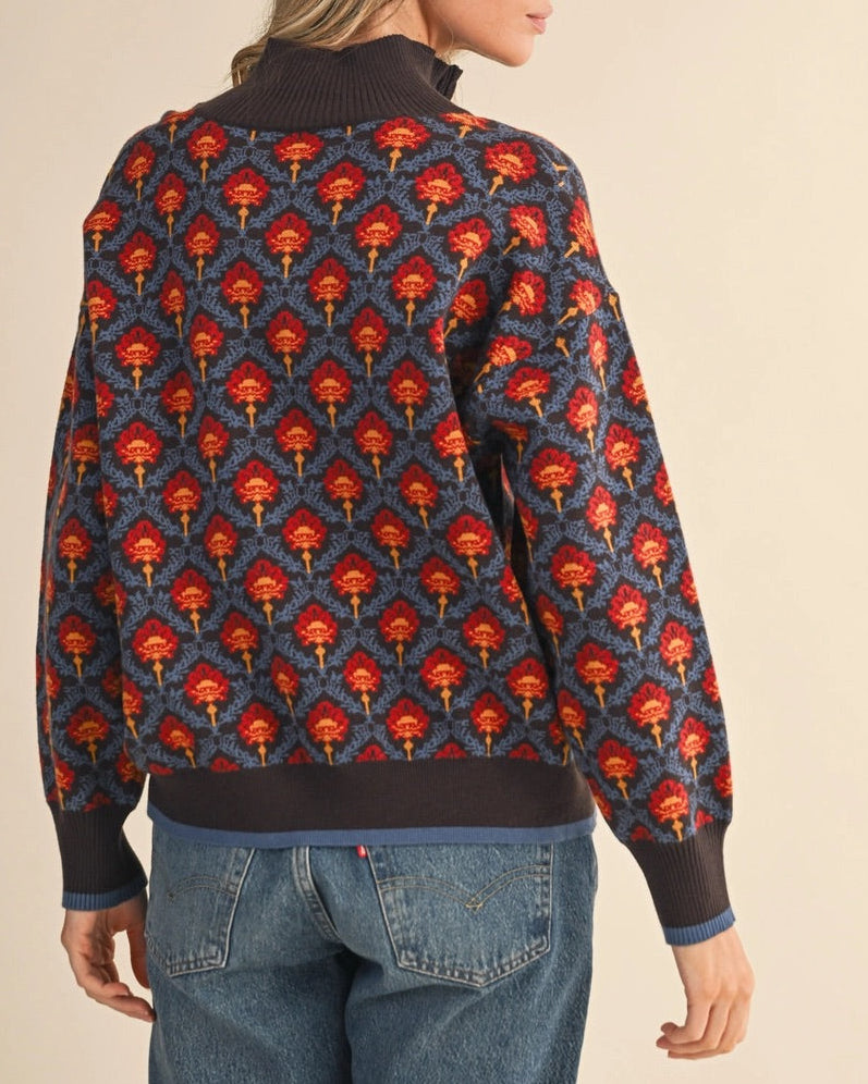 Patterned floral 1/2 zip brown and blue sweater with red and orange vintage floral accents on a white background.