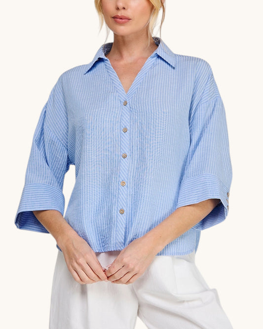 Hampton Breeze Woven Button Up Shirt with a classic collar and 3/4 length sleeves paired with white pants. 