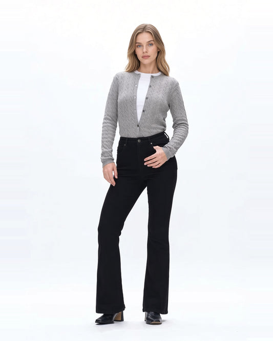 Woman wearing high rise flare denim black jeans with gray sweater and fitted white tee shirt and black boots.