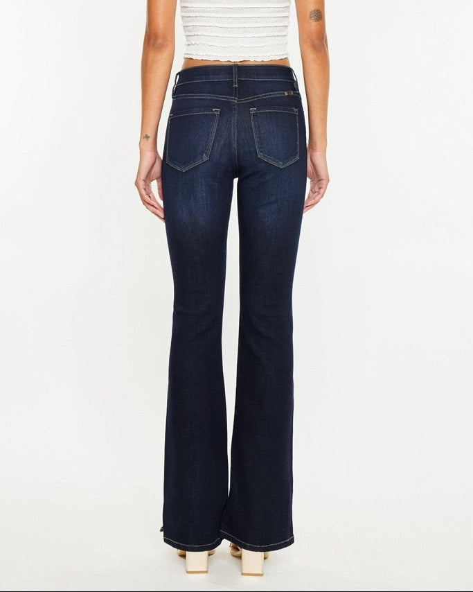 Woman wearing Kan Can Dark Wash High Rise Bootcut Jeans with side slit detail.
