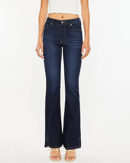 Woman wearing Kan Can Dark Wash High Rise Bootcut Jeans with side slit detail.