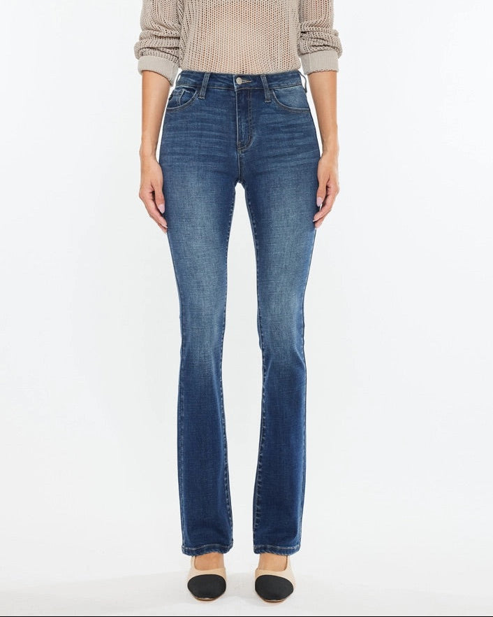 Woman wearing Kan Can High Rise Skinny Bootcut Jeans in medium wash denim.