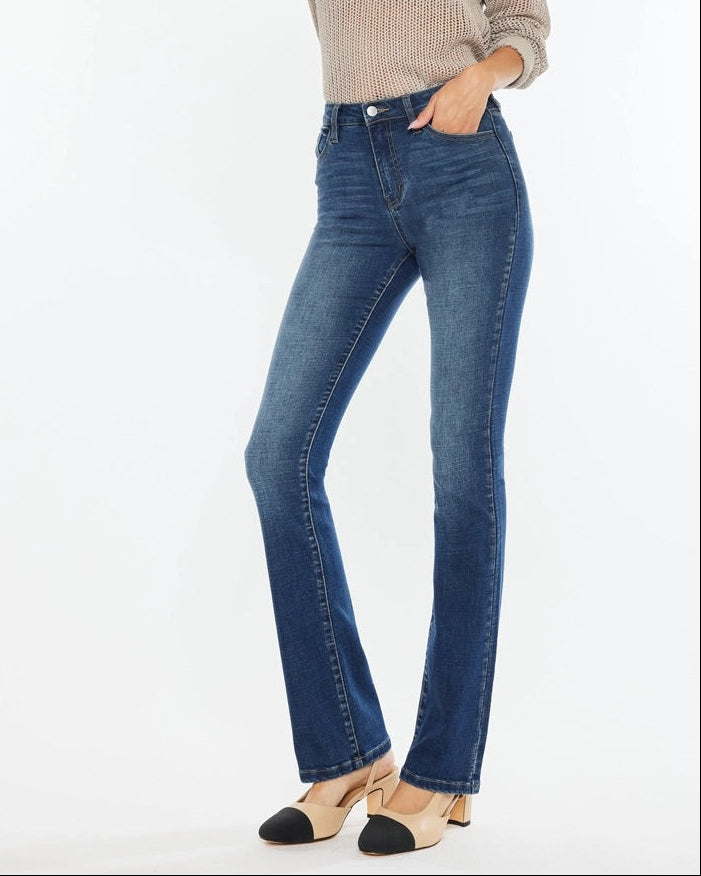 Woman wearing Kan Can High Rise Skinny Bootcut Jeans in medium wash denim.