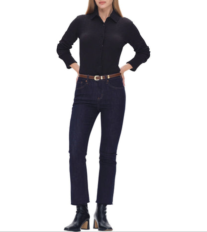 Woman wearing a black shirt and dark blue jeans on a white background.