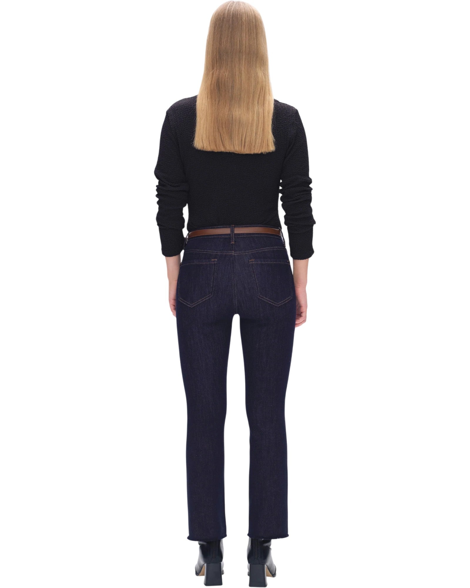 Person wearing dark jeans and a black top on a white background.