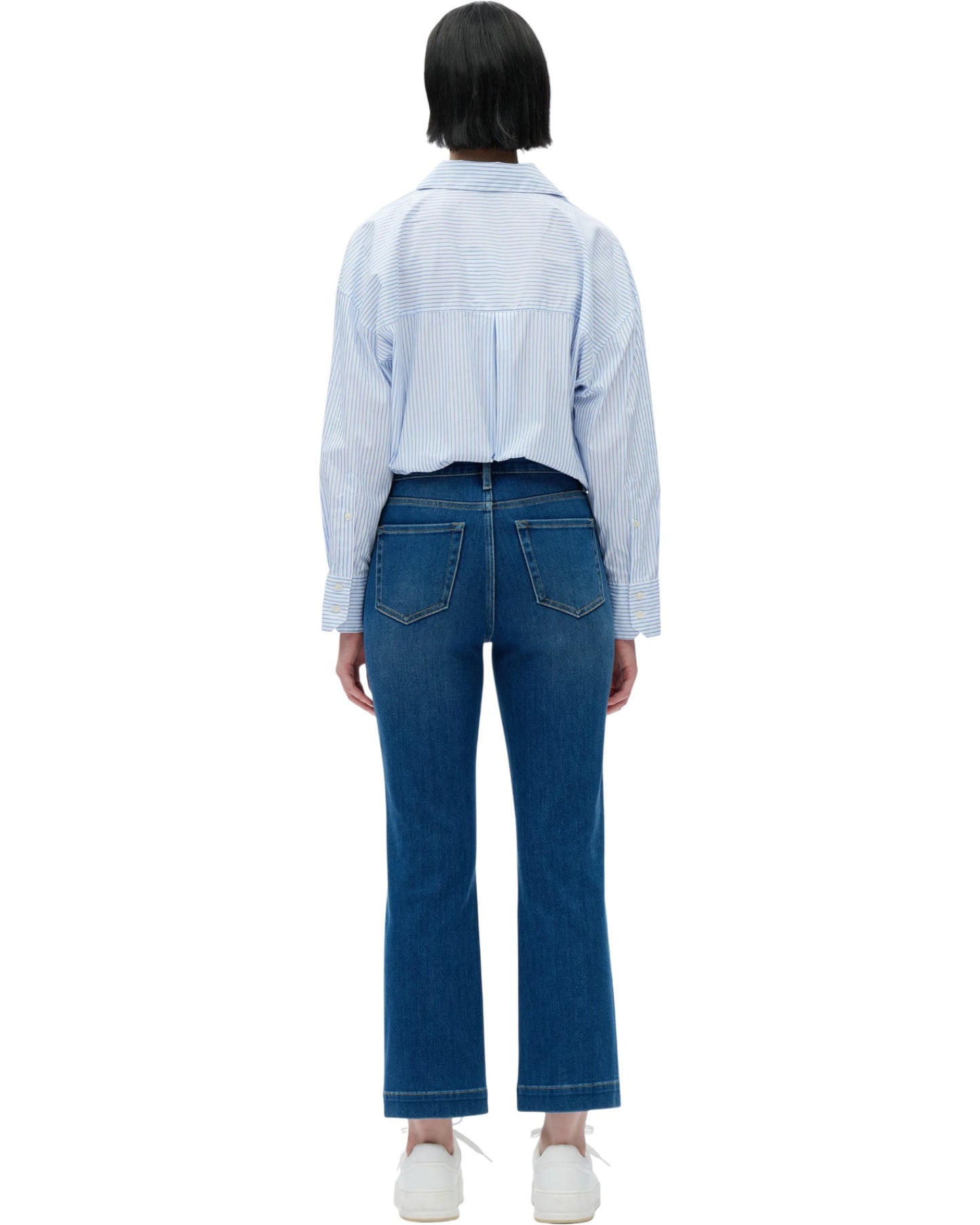 Person wearing a light blue checkered shirt and dark blue jeans on a white background.