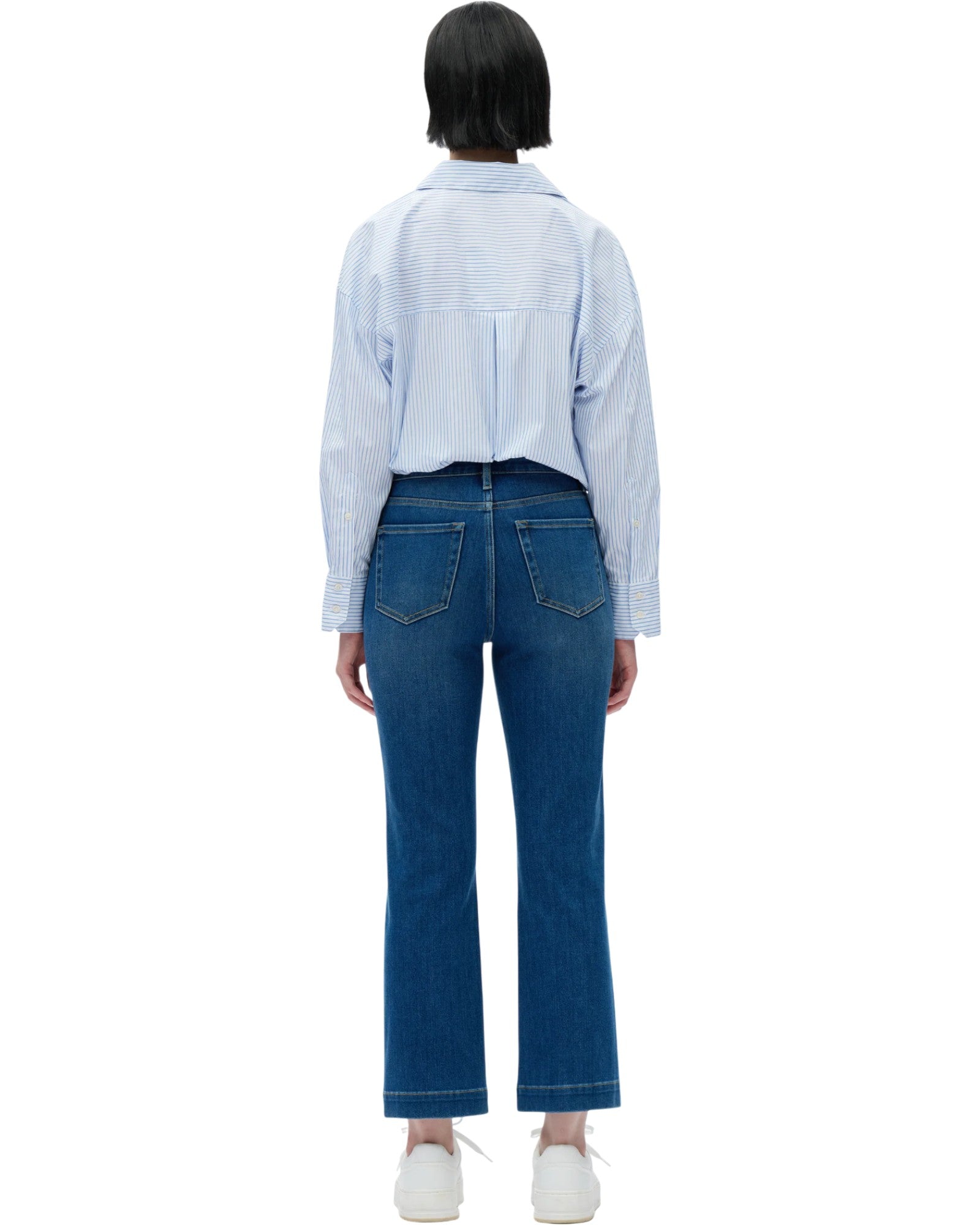 Person wearing a light blue checkered shirt and dark blue jeans on a white background.