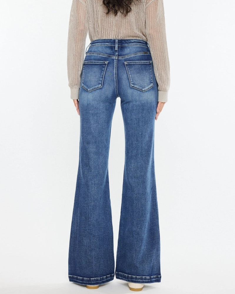 Woman wearing Kan Can High Rise Wide Leg Flare Jeans in medium wash denim.