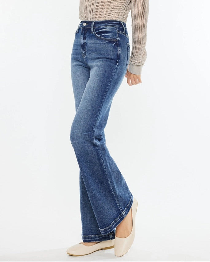 Woman wearing Kan Can High Rise Wide Leg Flare Jeans in medium wash denim.