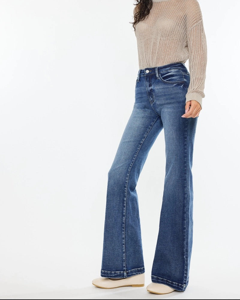Woman wearing Kan Can High Rise Wide Leg Flare Jeans in medium wash denim.