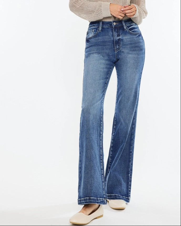 Woman wearing Kan Can High Rise Wide Leg Flare Jeans in medium wash denim.