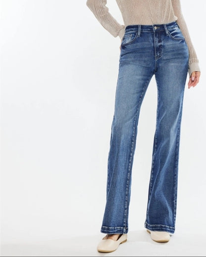 Woman wearing Kan Can High Rise Wide Leg Flare Jeans in medium wash denim.