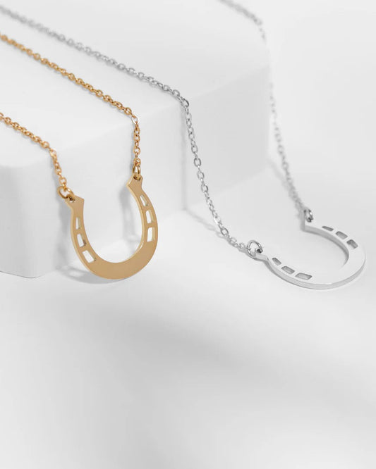 Gold and Silver Horseshoe pendant necklace on white background.