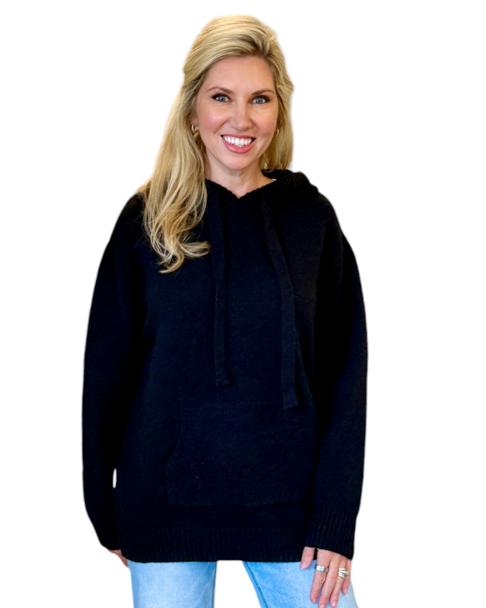 Woman wearing a soft, black oversized hoodie sweater.