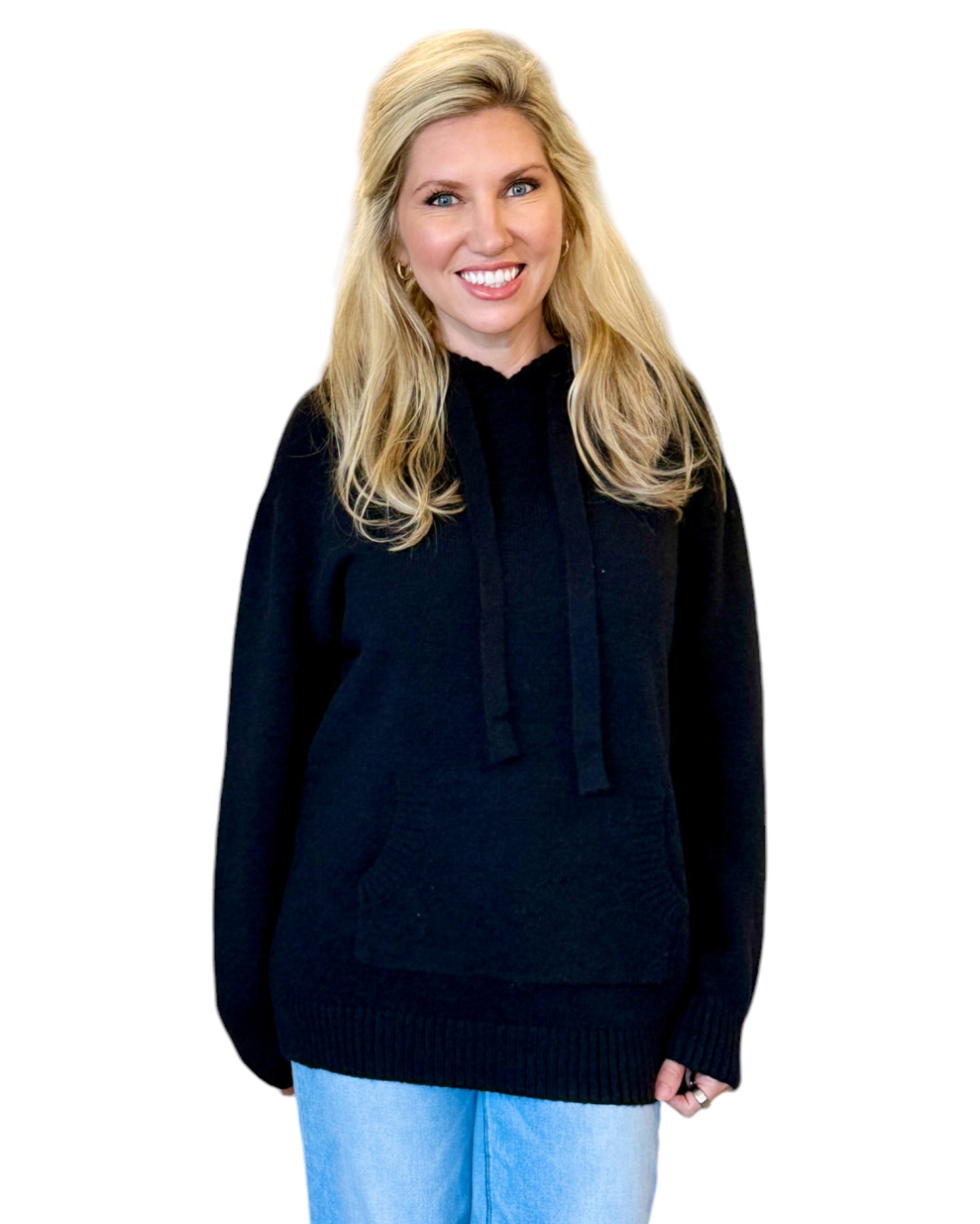 Woman wearing a soft, black oversized hoodie sweater.