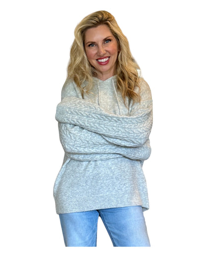 Model wearing an Antique Rose Women's Hoodie featuring wide cable-knit braided sleeves, a cozy marled sweater knit bodice, and an oversized fit.