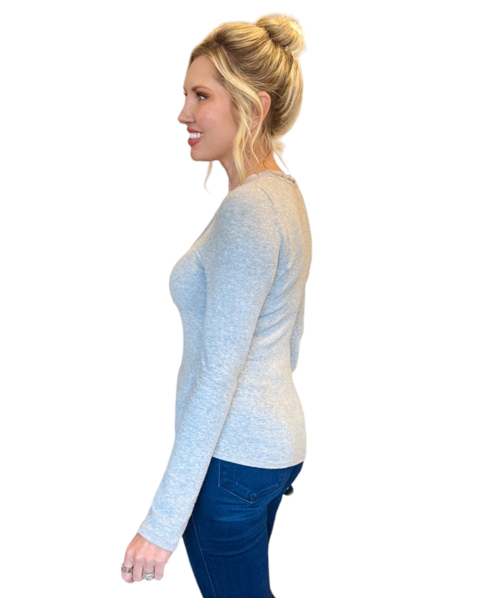 Woman wearing grey soft ribbed long sleeve top with lace tie accent.