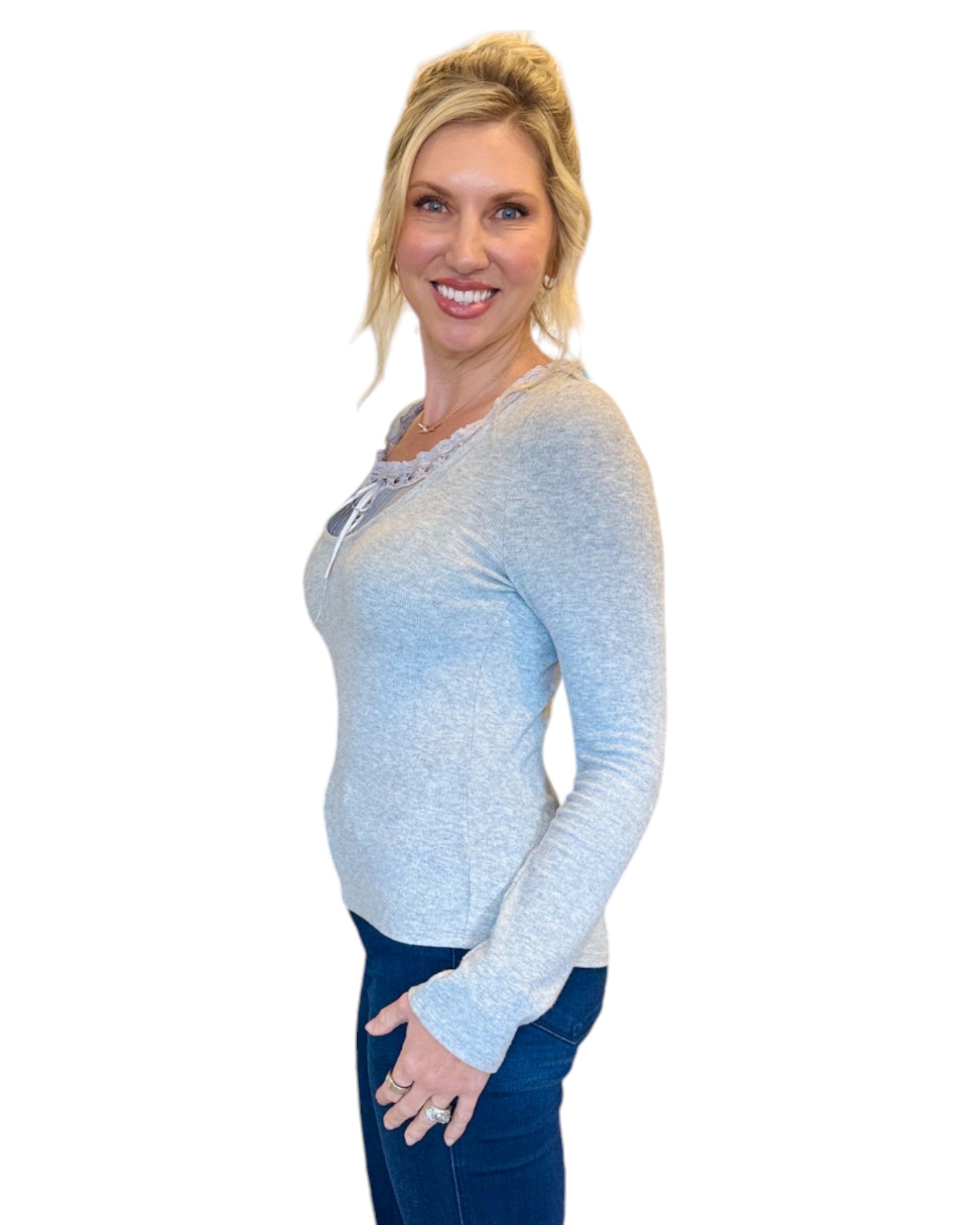 Woman wearing grey soft ribbed long sleeve top with lace tie accent.