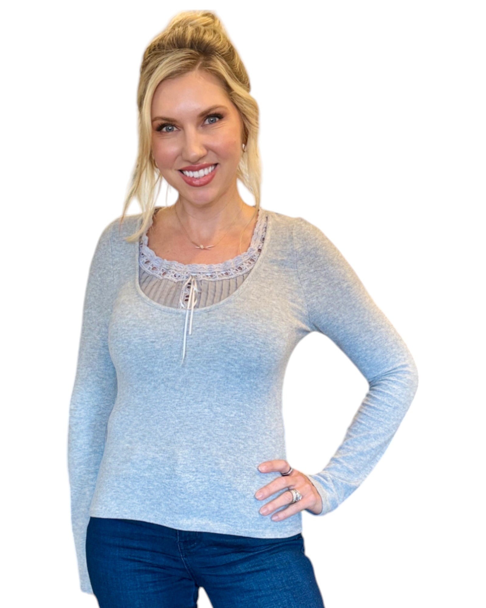 Woman wearing grey soft ribbed long sleeve top with lace tie accent.