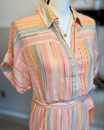 Colorful striped dress on a mannequin with a blurred background.