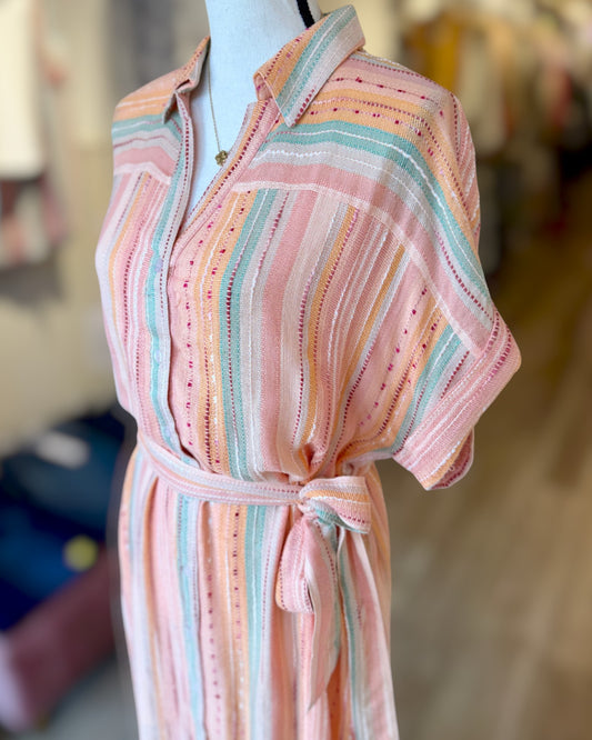 Mannequin wearing a colorful striped dress with a blurred background.