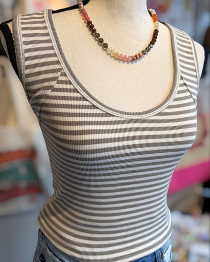 Striped tank top on a mannequin with a blurred background.