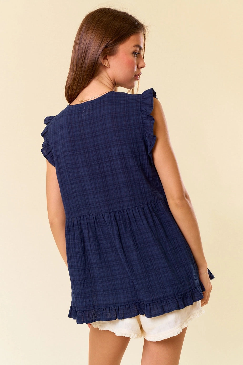 Navy gingham sleeveless tank top with ruffle trim and babydoll silhouette.