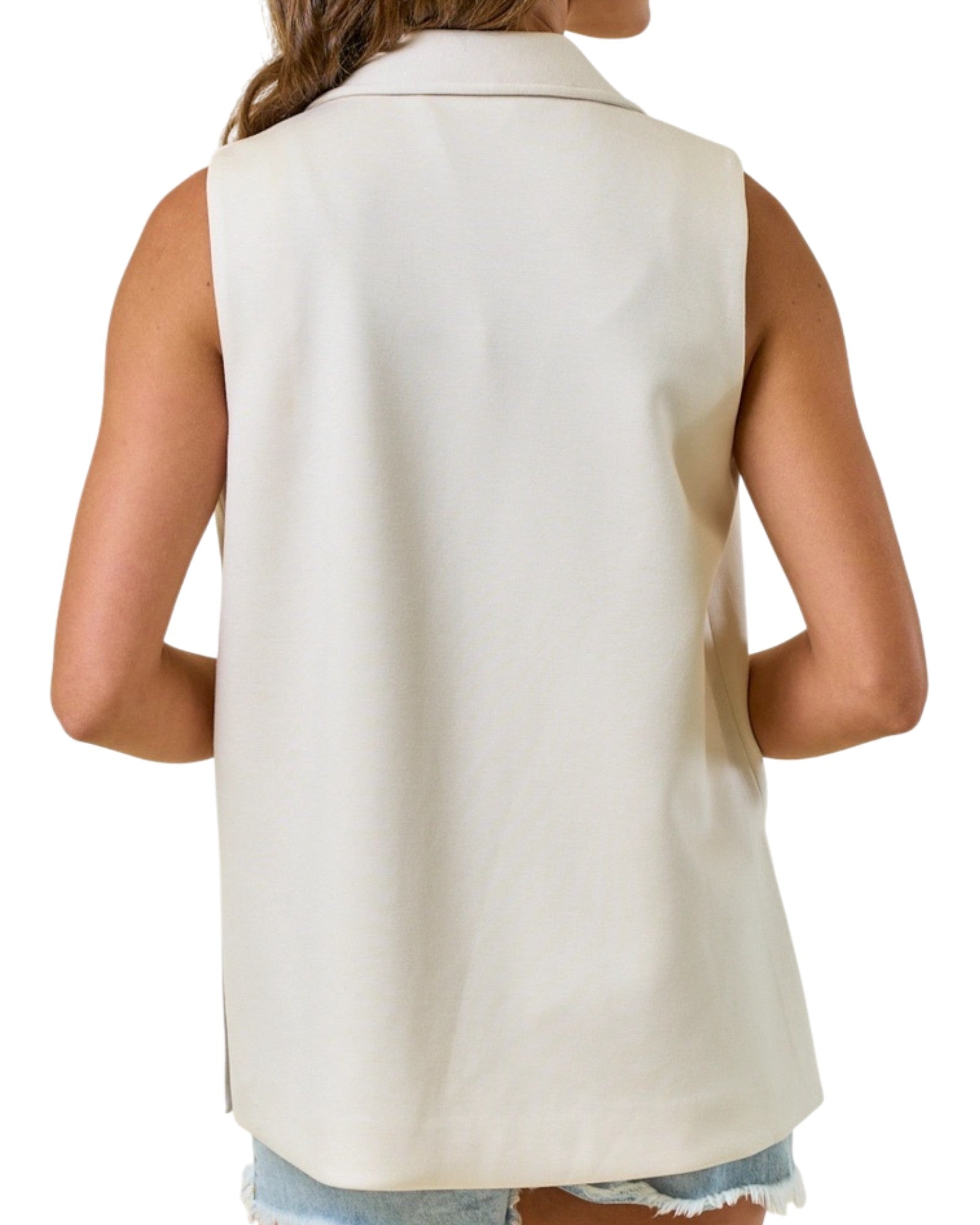 Woman wearing a sleeveless blazer vest with black tank top. 