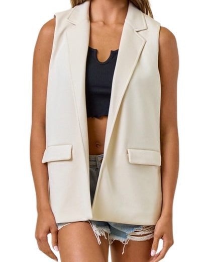 Woman wearing a sleeveless blazer vest with black tank top. 