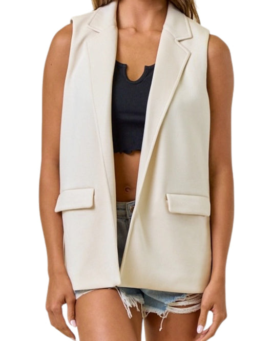 Woman wearing a sleeveless blazer vest with black tank top. 