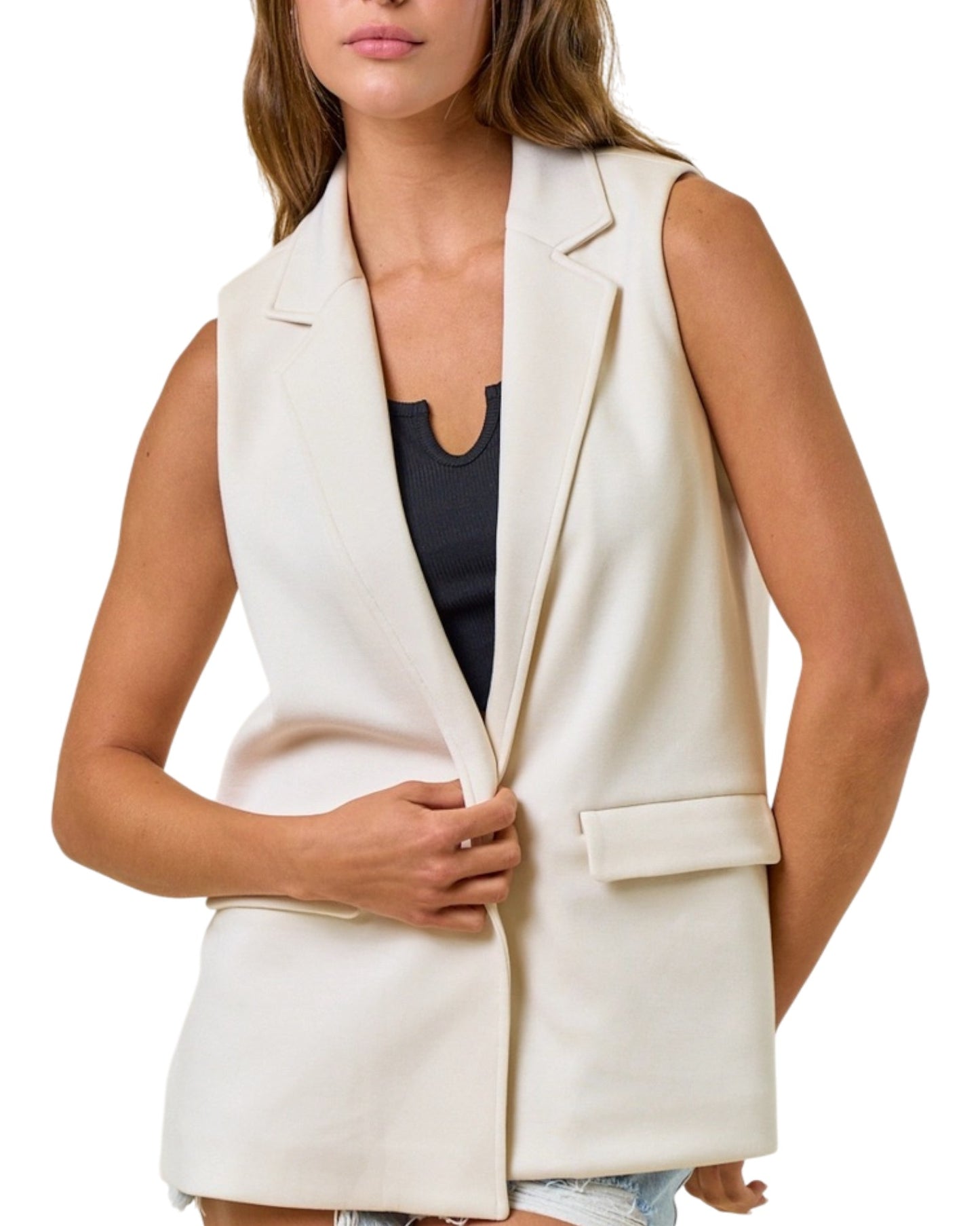 Woman wearing a sleeveless blazer vest with black tank top. 