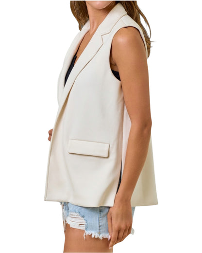 Woman wearing a sleeveless blazer vest with black tank top. 