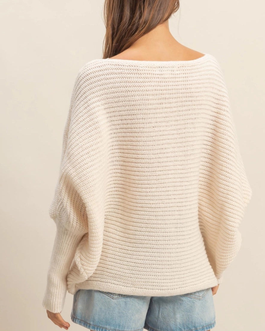  Ivory oversized dolman sweater with wide-knit texture and relaxed fit.