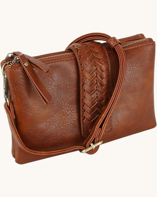 Brown leather clutch with braided strap on a white background