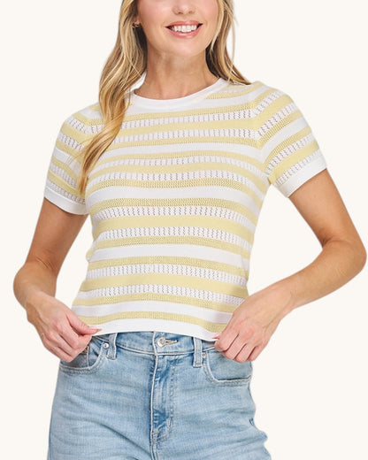 Woman wearing a Limoncello Fine Gauge Knit Top in a sunny yellow and white paired with denim. 