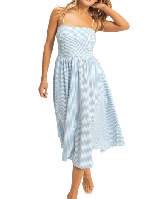 Woman wearing a light blue striped dress on a white background