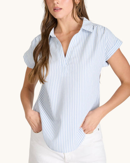 Woman wearing a light blue and white striped shirt on a white background.