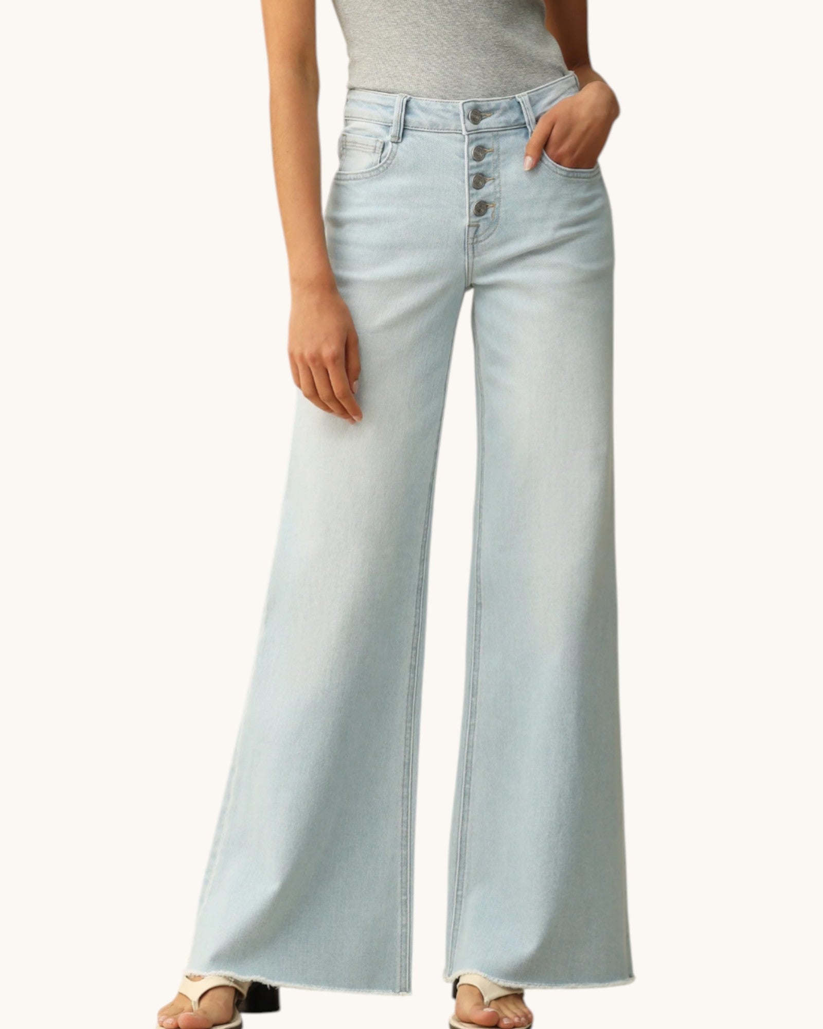 Light blue flared jeans worn by a person on a white background.