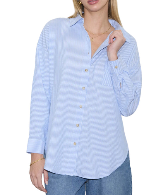 Woman wearing a light blue striped shirt with a white background.