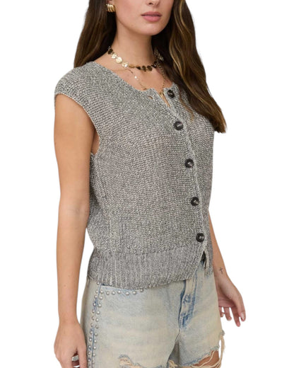Woman wearing a gray knitted vest with black buttons on a white background.