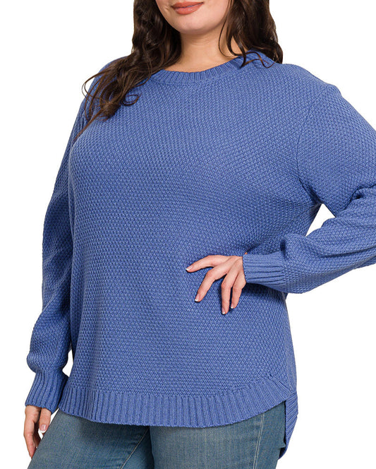 Woman wearing a blue sweater and jeans on white background. 