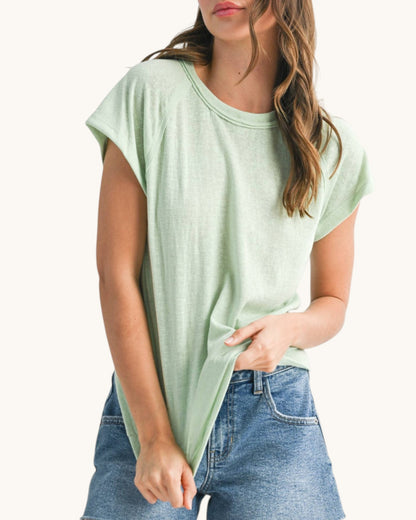 Woman wearing a casual relaxed fit baseball tee in light mint hue. 