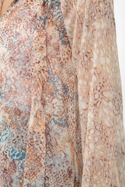 Close-up of animal print patterned fabric with earthy tones on a plain background.